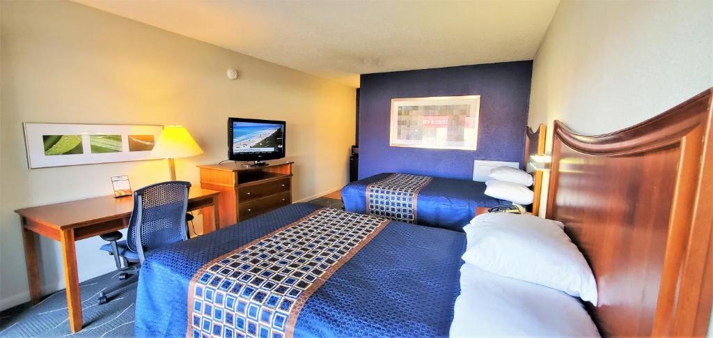 a hotel room with a bed and a desk at Economy 7 Inn- Newport News in Newport News