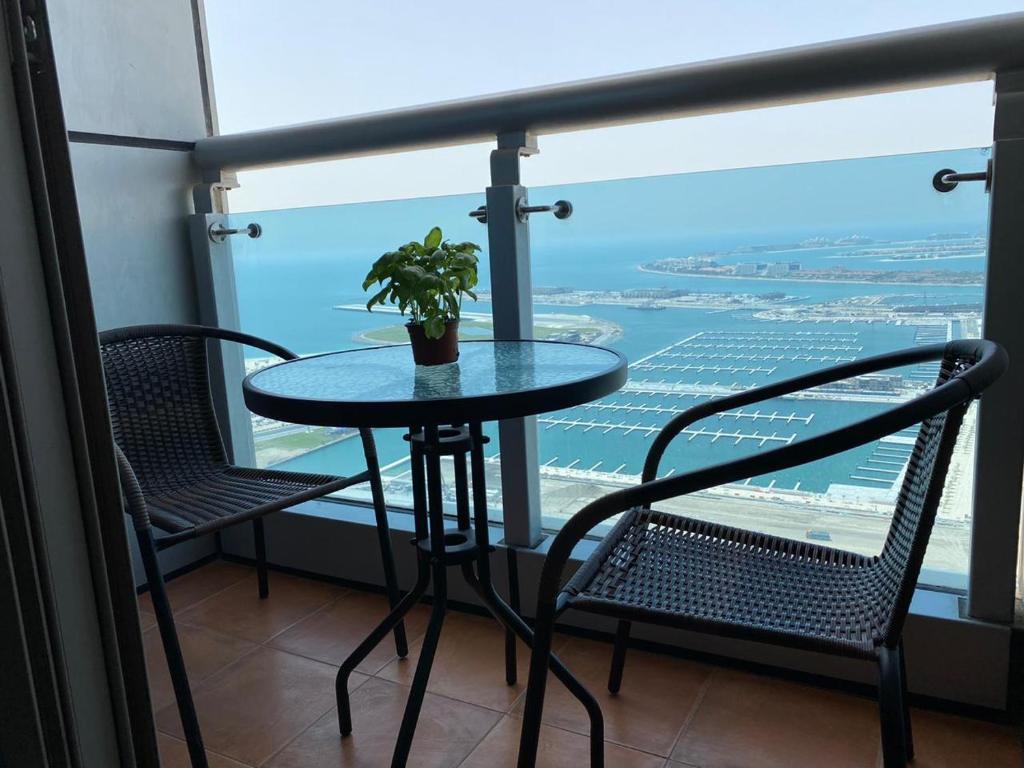 a table with chairs and a plant on a balcony at Beachfront Property With Atlantis The Palm & Skydive View In Dubai Marina in Dubai