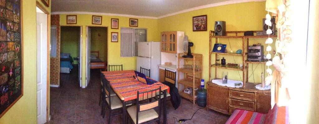 cocina con mesa y cocina con paredes amarillas en Cota6000 Expediciones Dpto A, en San Pedro de Atacama
