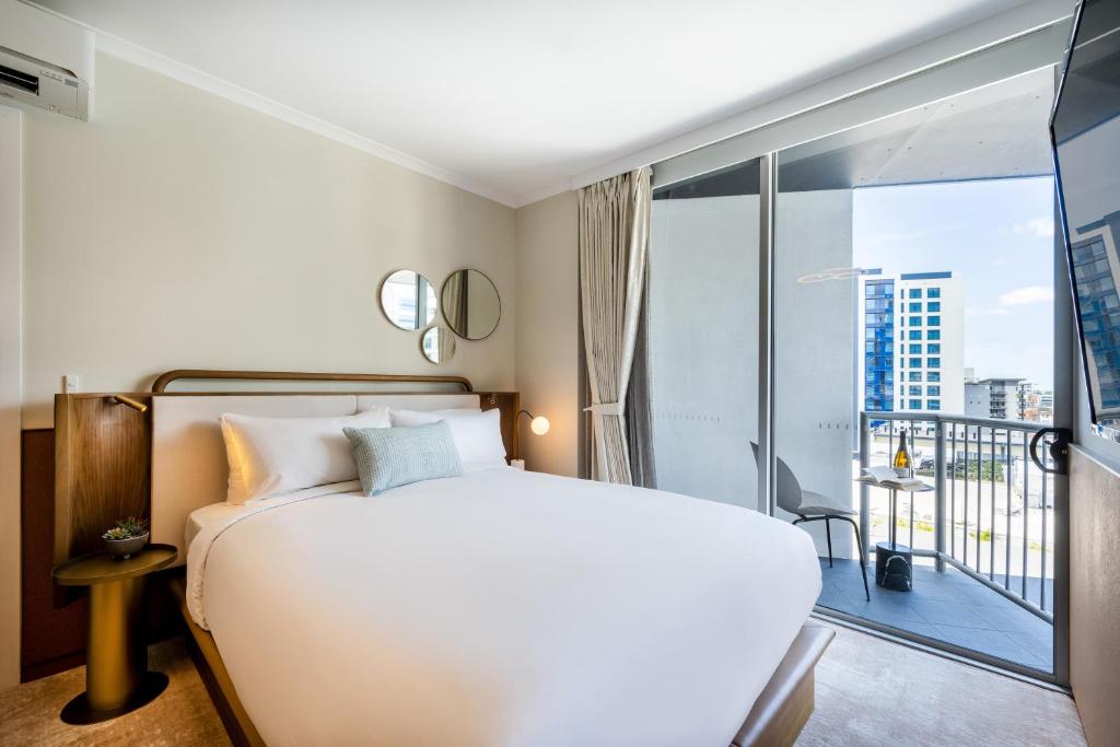 1 dormitorio con cama blanca y balcón en Mantra Terrace Hotel en Brisbane