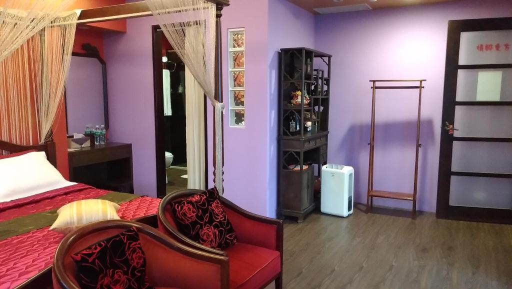 a bedroom with a bed and a chair and purple walls at Good Time B&amp;B in Jiufen