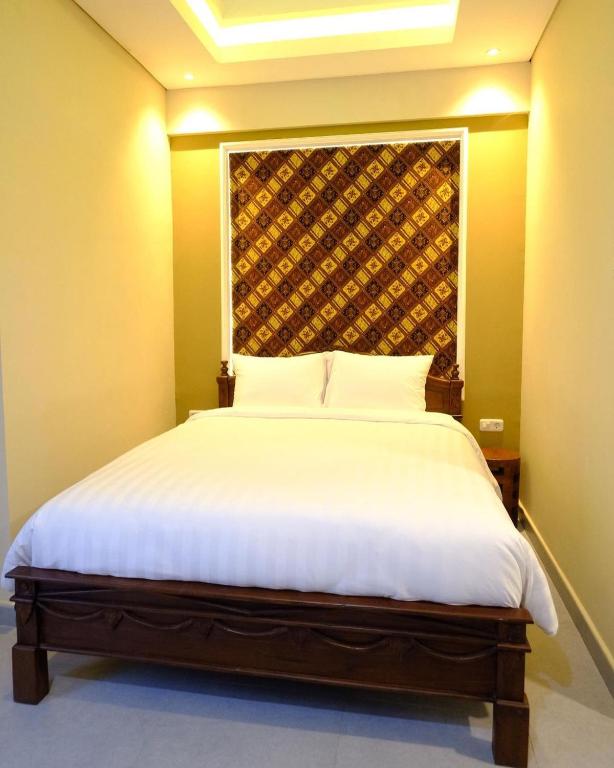Postel nebo postele na pokoji v ubytování Americano Hotel Syariah Yogyakarta