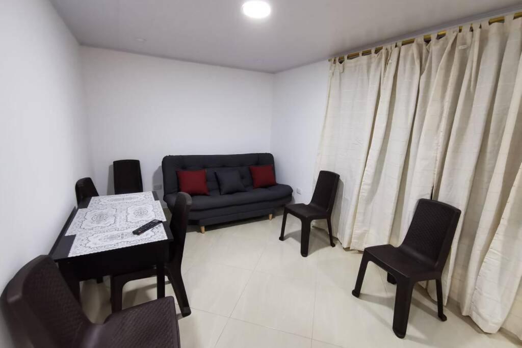サン・ラファエルにあるHermoso y cómodo apartamentoのリビングルーム(ソファ、テーブル、椅子付)