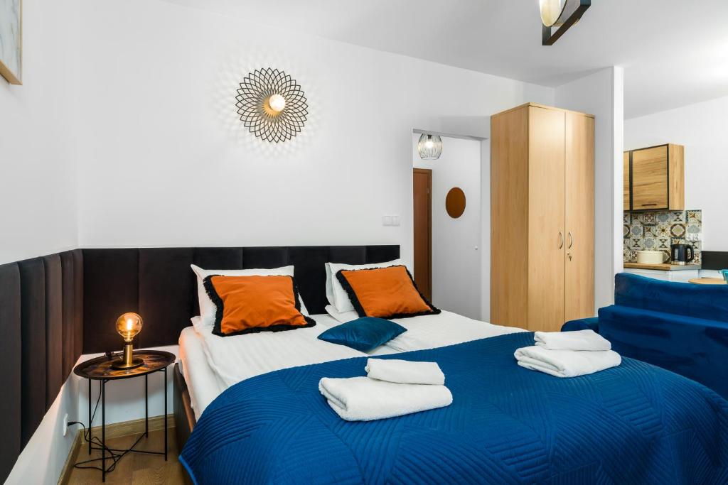 a bedroom with a blue and white bed with towels on it at Sleepway Apartments - Modern Dream in Poznań