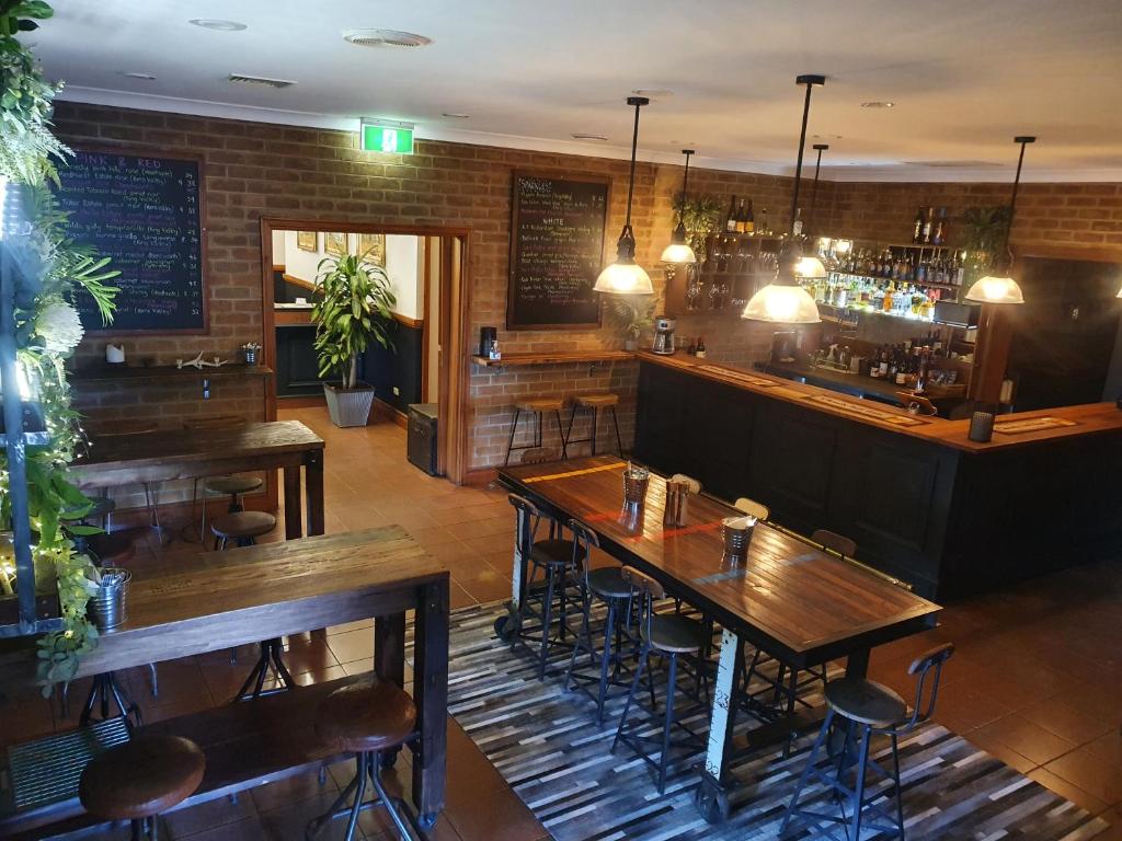 un restaurante con mesas de madera y un bar en The Lancefield Lodge, en Lance Field