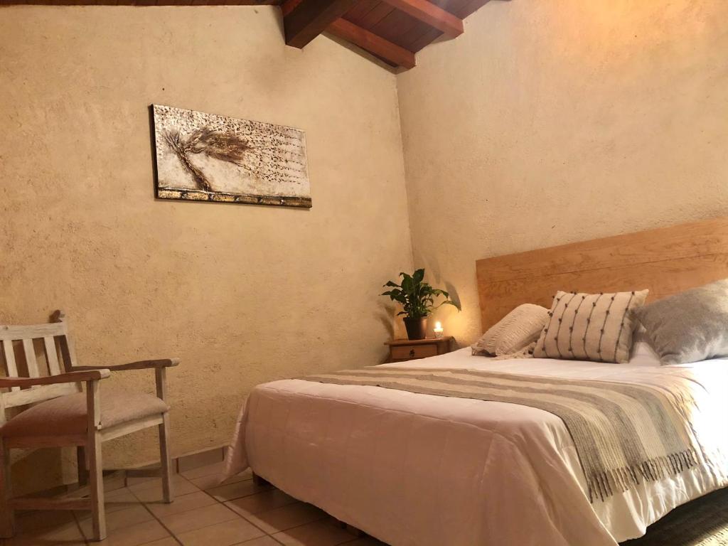 a bedroom with a bed and a table and a chair at Departamento Rinconcito olivo, 5min centro, home office in Valle de Bravo