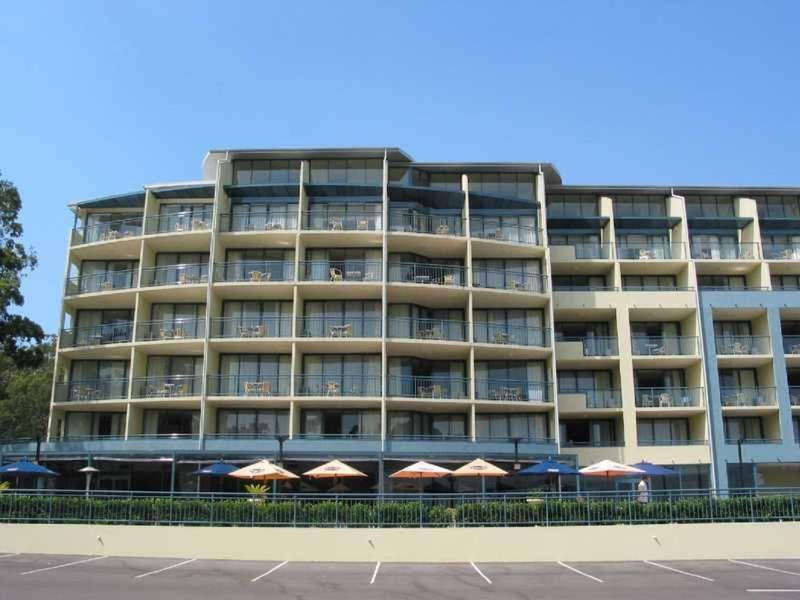 un grand bâtiment avec des parasols en face de celui-ci dans l'établissement Casablanca In Landmark Resort, à Nelson Bay