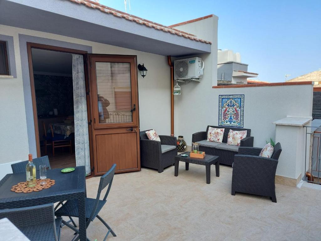 a patio with a couch and a table and chairs at Terrazza New Homes in Castellammare del Golfo