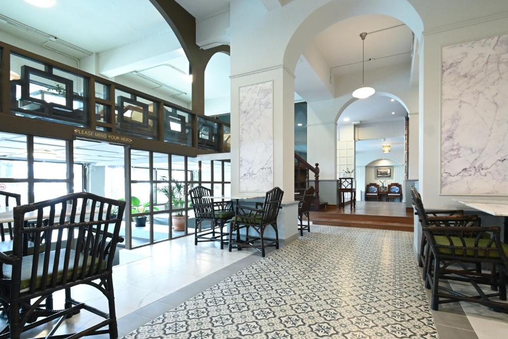 a lobby with chairs and a table in a building at The Krungkasem Srikrung Hotel in Bangkok