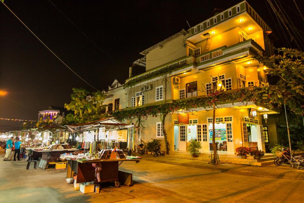 un edificio con mesas delante de él por la noche en Moon's Homestay, en Hoi An