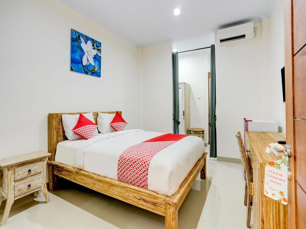 Schlafzimmer mit einem Bett mit roten und weißen Kissen in der Unterkunft SUPER OYO 90232 March 67 Stay in Balian