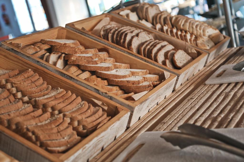 a bunch of different types of bread in wooden trays at Ohtels Carabela in Matalascañas