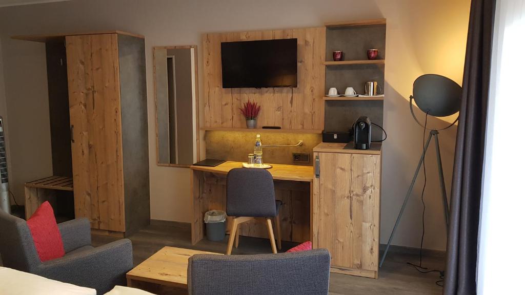 a room with a desk and chairs and a television at Hotel-Restaurant Zur Linde in Secklendorf