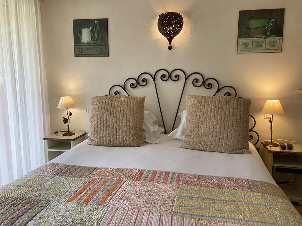 a bedroom with a large white bed with two pillows at La Résidence du Moulin in Tourrettes-sur-Loup