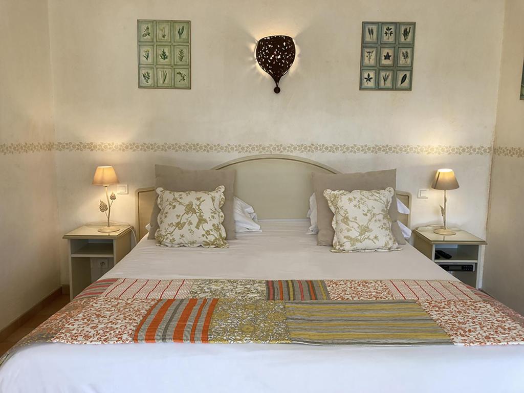 a bedroom with a large bed with two night stands at La Résidence du Moulin in Tourrettes-sur-Loup