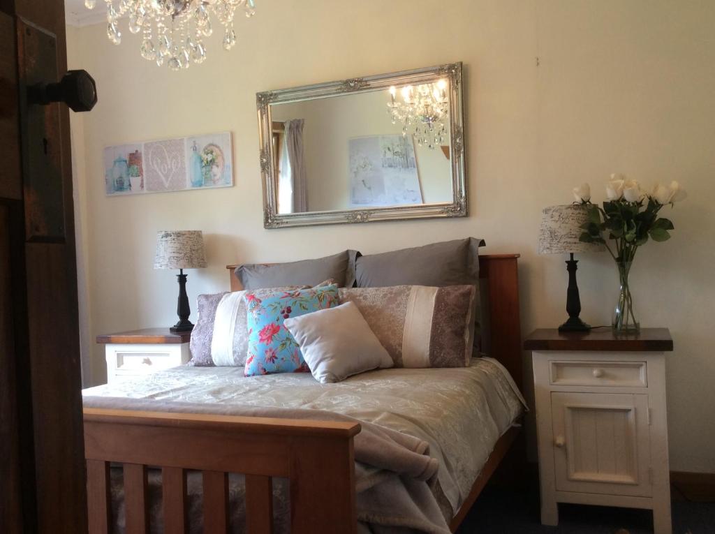 een slaapkamer met een bed met een spiegel aan de muur bij Rural Country Retreat in New Plymouth