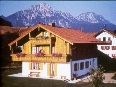 ein Haus mit Balkon und Bergen im Hintergrund in der Unterkunft Mayerbauer in Piding