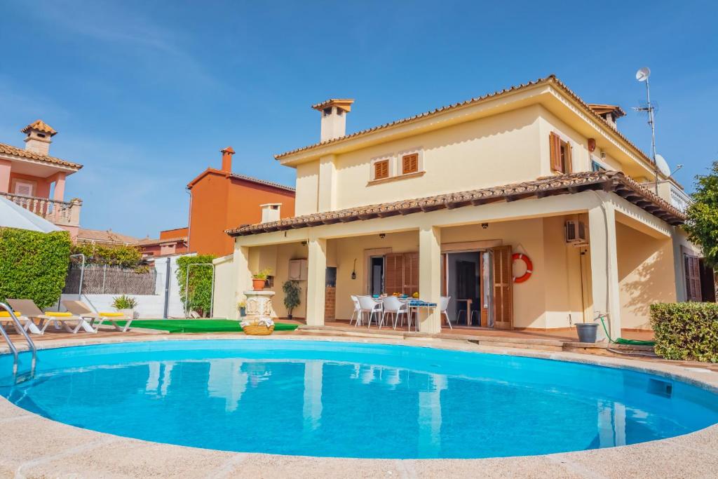 eine Villa mit einem Pool vor einem Haus in der Unterkunft Caulls in Palma de Mallorca