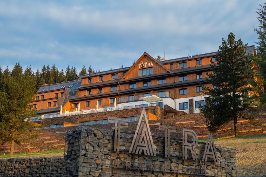 ein großes Gebäude mit einem Schild davor in der Unterkunft Grandhotel Tatra in Velké Karlovice