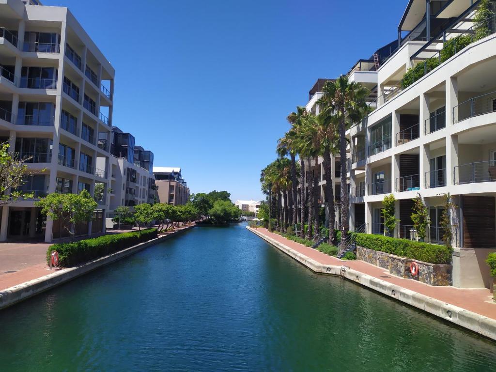 a river in a city with apartment buildings at One Bedroom Apartment - fully equipped Waterfront based in Cape Town