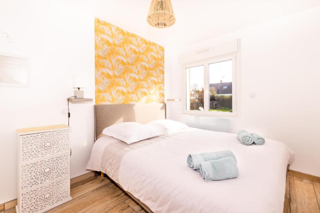 Habitación blanca con cama y ventana en Gite de la Baie des anges, en Saint-Valery-sur-Somme