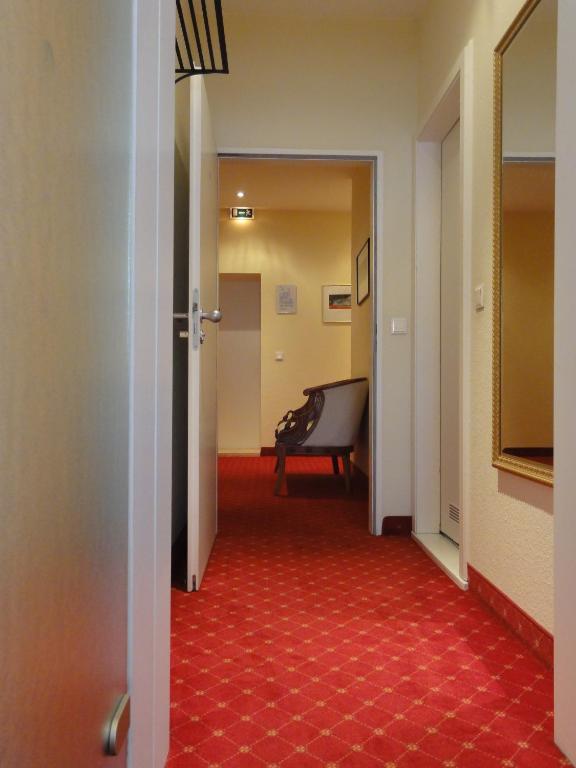 a hallway with a red carpet and a piano at Pension Zeitlos in Potsdam