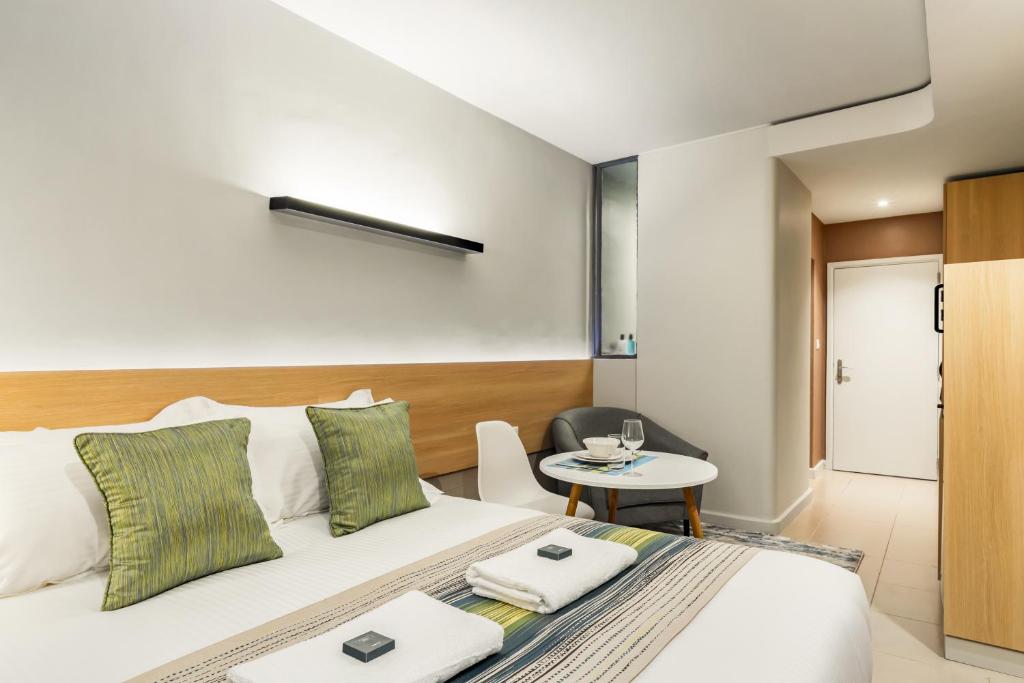 a hotel room with a bed and a table at Kozi Suites Nairobi Airport in Nairobi