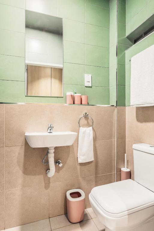 a bathroom with a sink and a toilet at Kozi Suites Nairobi Airport in Nairobi