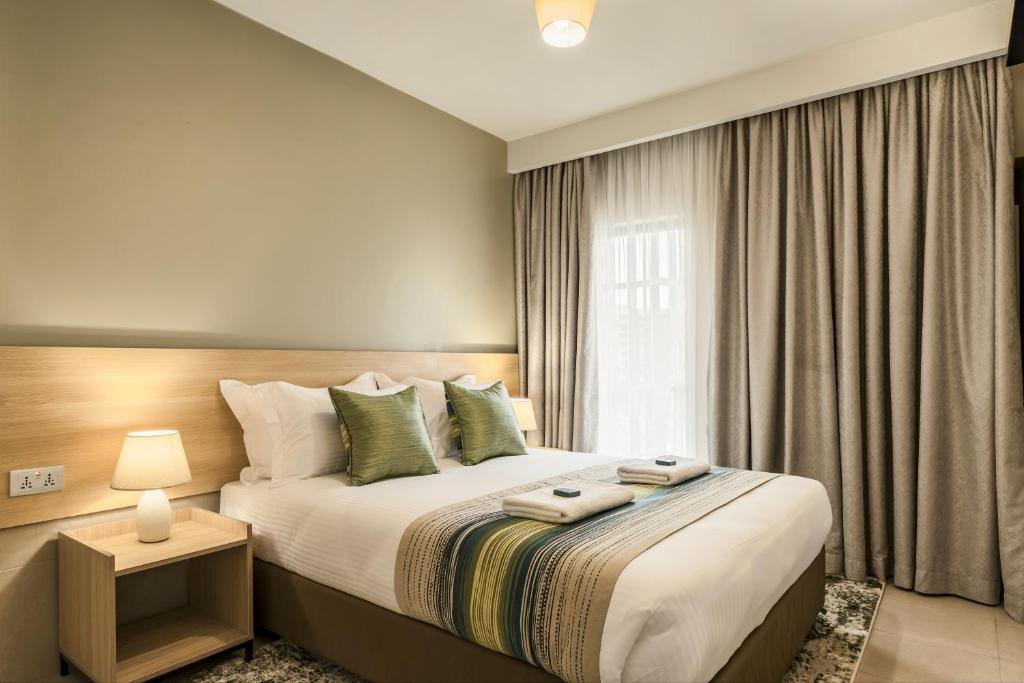 a bedroom with a large bed with a window at Kozi Suites Nairobi Airport in Nairobi
