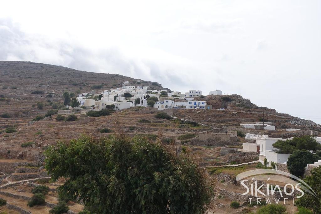 a group of white buildings on a hill at Comfy Room with Adorable View in Síkinos