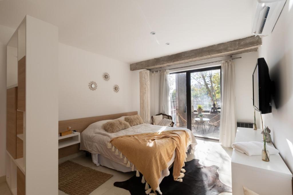 1 dormitorio con cama y ventana grande en Cbmona Suites en Villa Mercedes