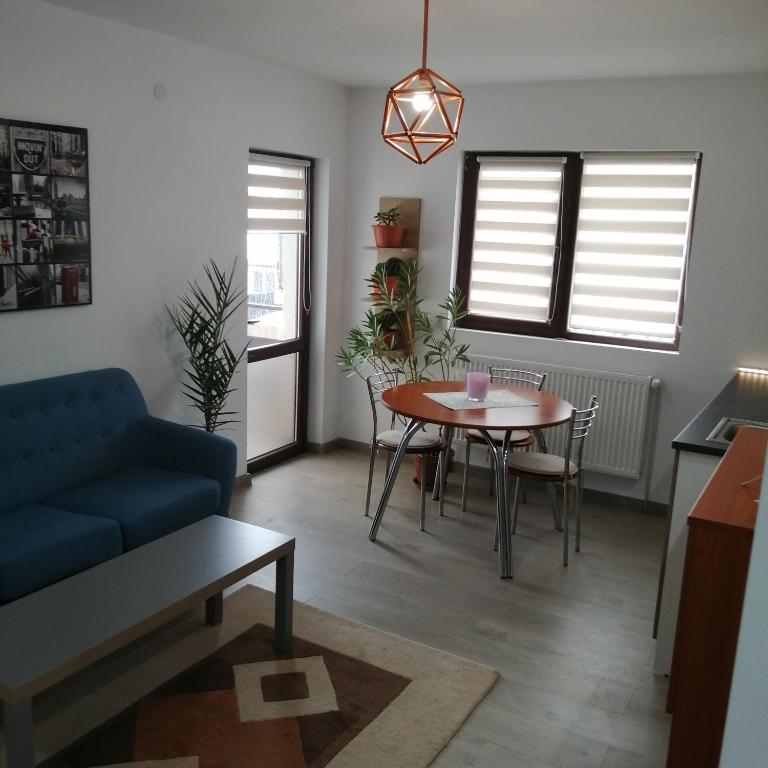 a living room with a table and a blue couch at Villa 38 Silviu Apartment in Bucharest