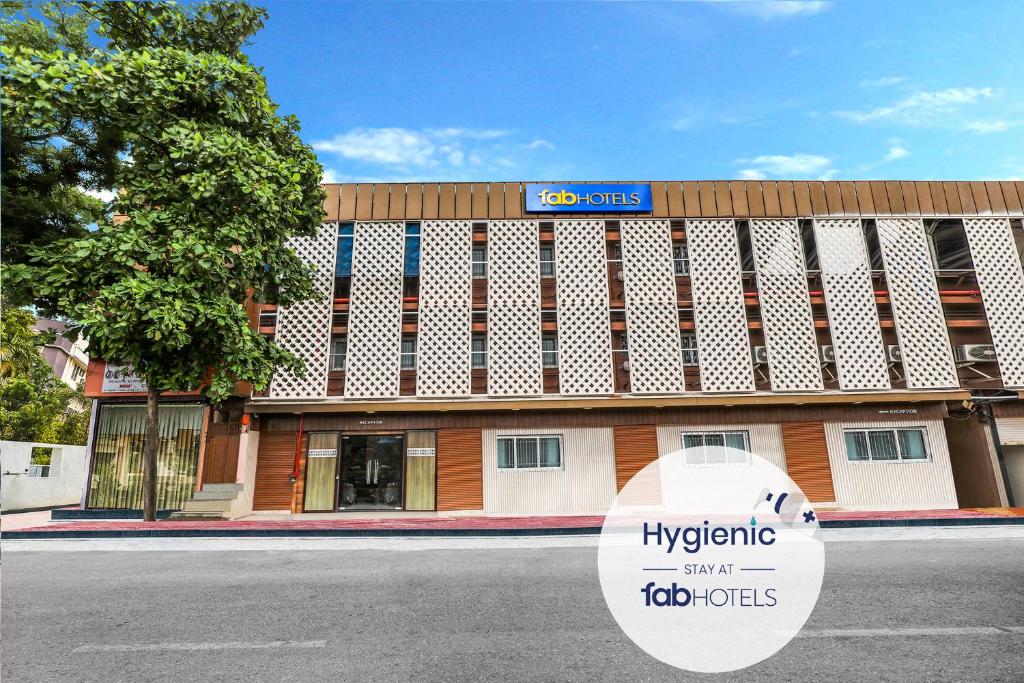 a large building with a sign in front of it at FabHotel Landmark Guestline Vashi in Navi Mumbai