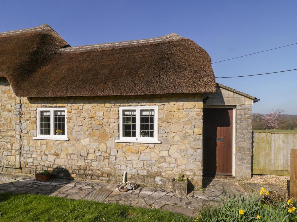 uma antiga casa de pedra com telhado de palha em Field View em Taunton