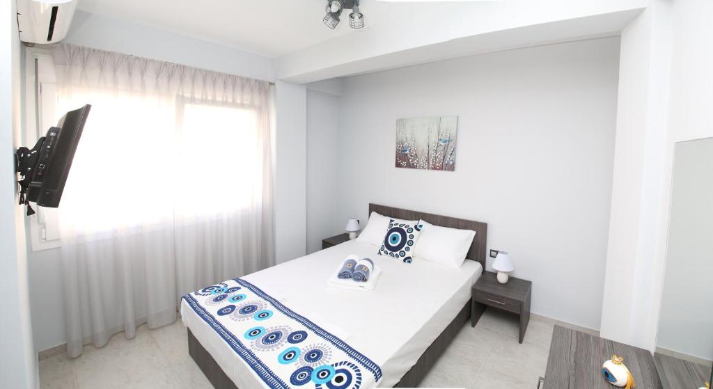 a white bedroom with a bed and a window at Luxury Villa Siniori in Keramotí