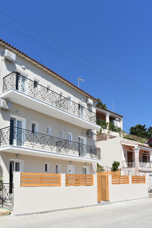 a white building with balconies on the side of it at Roys Blu in Kavos