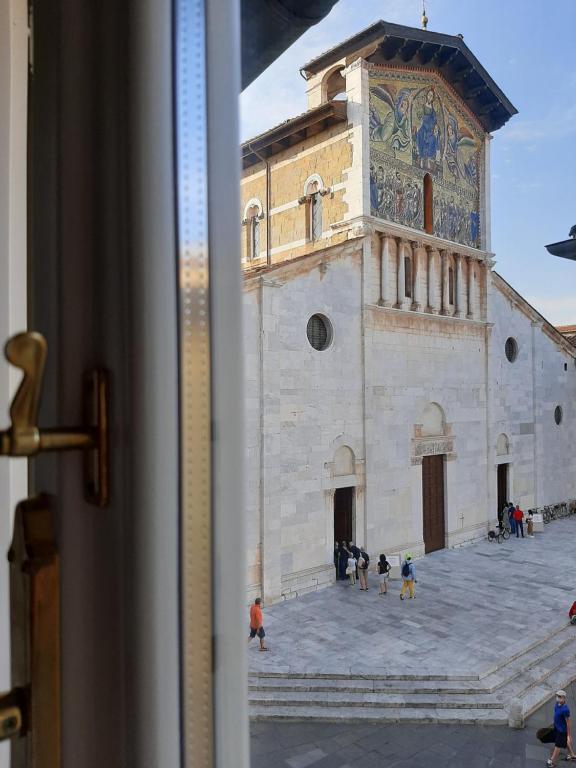 un edificio con una torre de reloj con gente delante en Il Vicolo, en Lucca