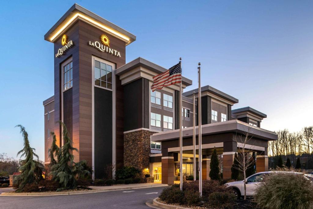 a hotel with an american flag in front of it at La Quinta by Wyndham Forsyth in Forsyth