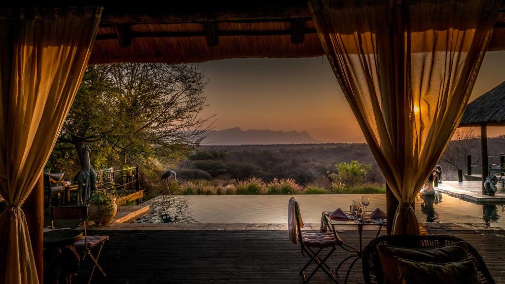 a patio with a table and chairs with a view at Khaya Ndlovu Safari Manor in Hoedspruit