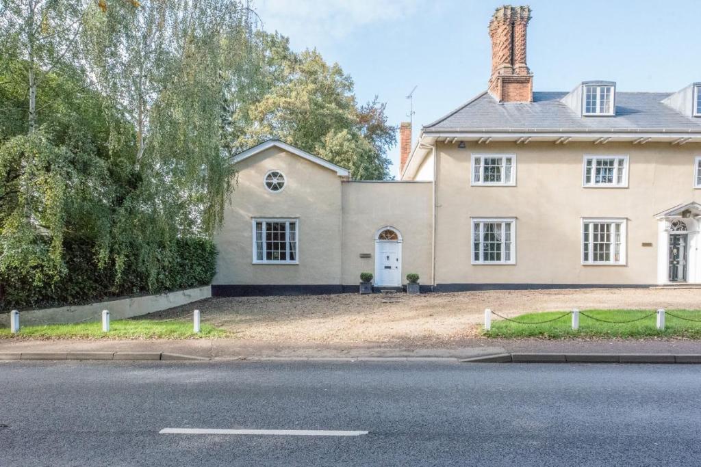 uma casa grande no lado de uma estrada em Cliftons Cottage, Clare em Sudbury