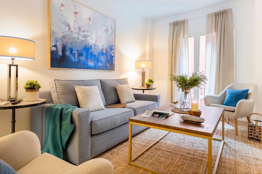 a living room with a couch and a table at Genteel Home Baños in Seville