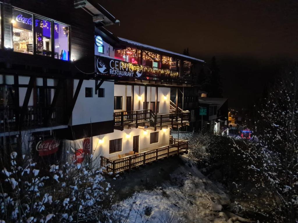 ein Gebäude mit Lichtern an der Seite in der Nacht in der Unterkunft Ski Top Busteni in Buşteni