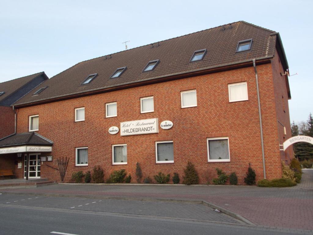 ein großes rotes Backsteingebäude mit einem Schild darauf in der Unterkunft Hotel & Restaurant Hildebrandt in Breitenrode