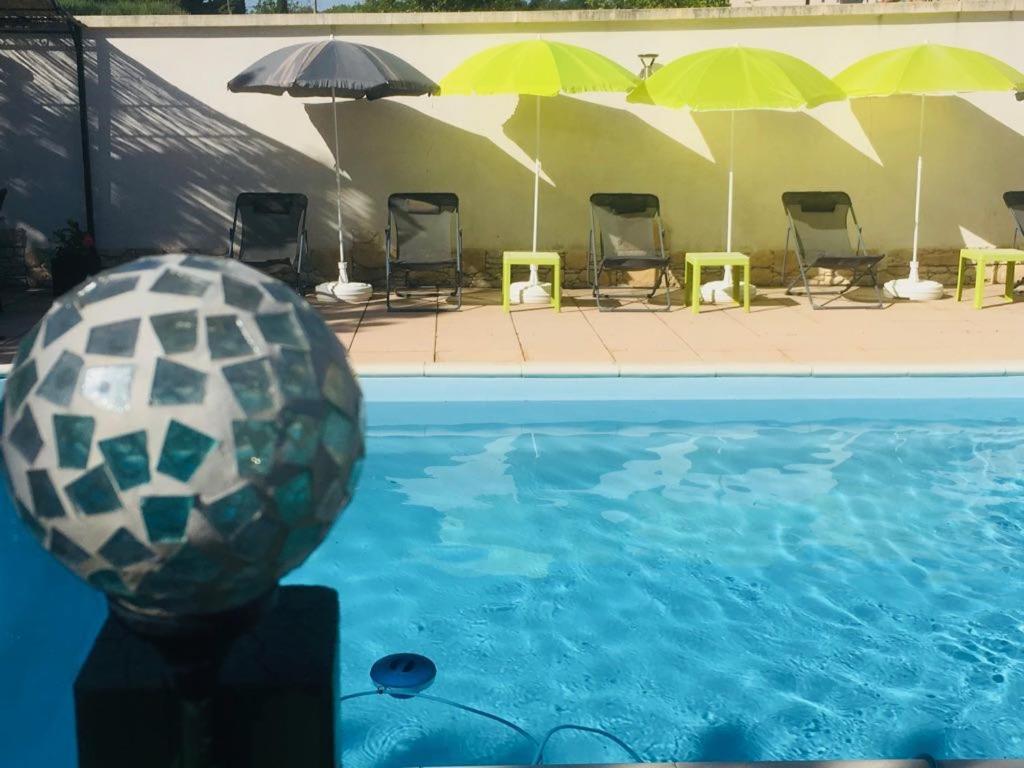 a soccer ball in the water next to a swimming pool at Le Clos des Gites, maisons de vacances, in Châteauneuf-Val-Saint-Donat