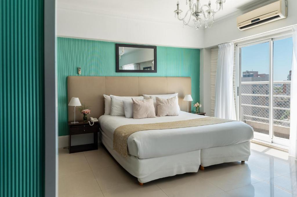 Un dormitorio con una cama grande y una pared verde en Ker Urquiza Hotel en Buenos Aires