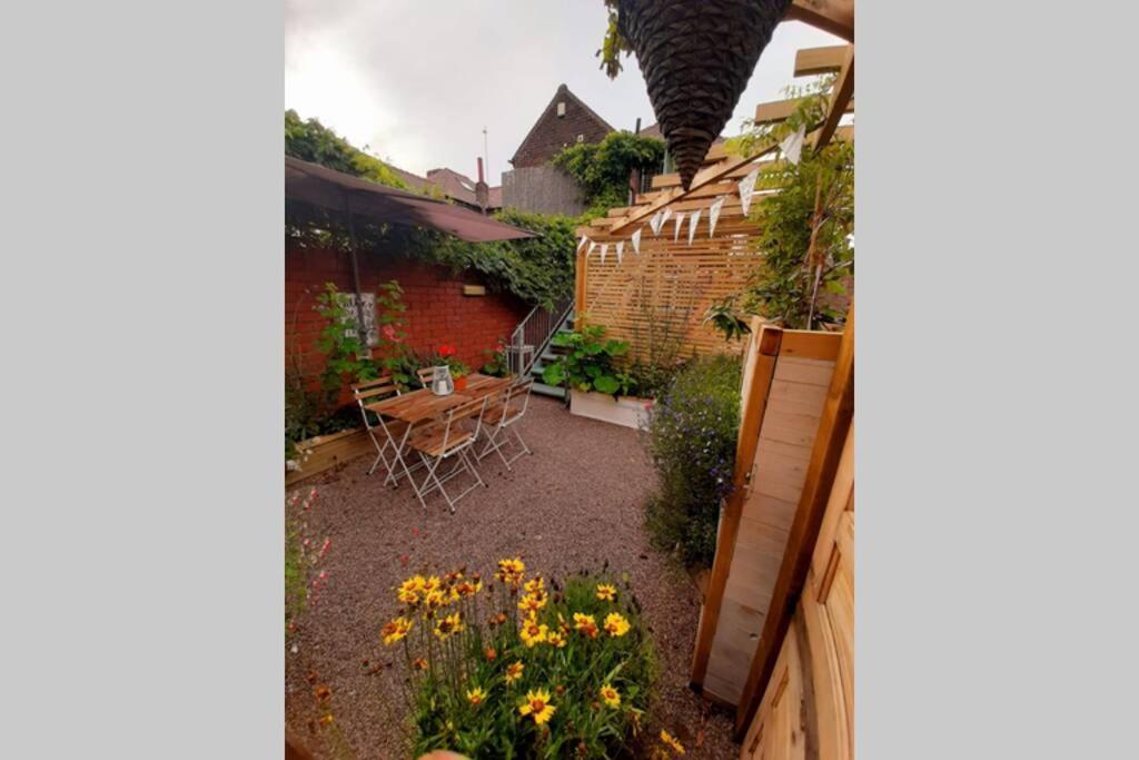 a small garden with a table and flowers in a yard at Unique 2 Bedroom Apartment in the Ideal Location in Blackpool