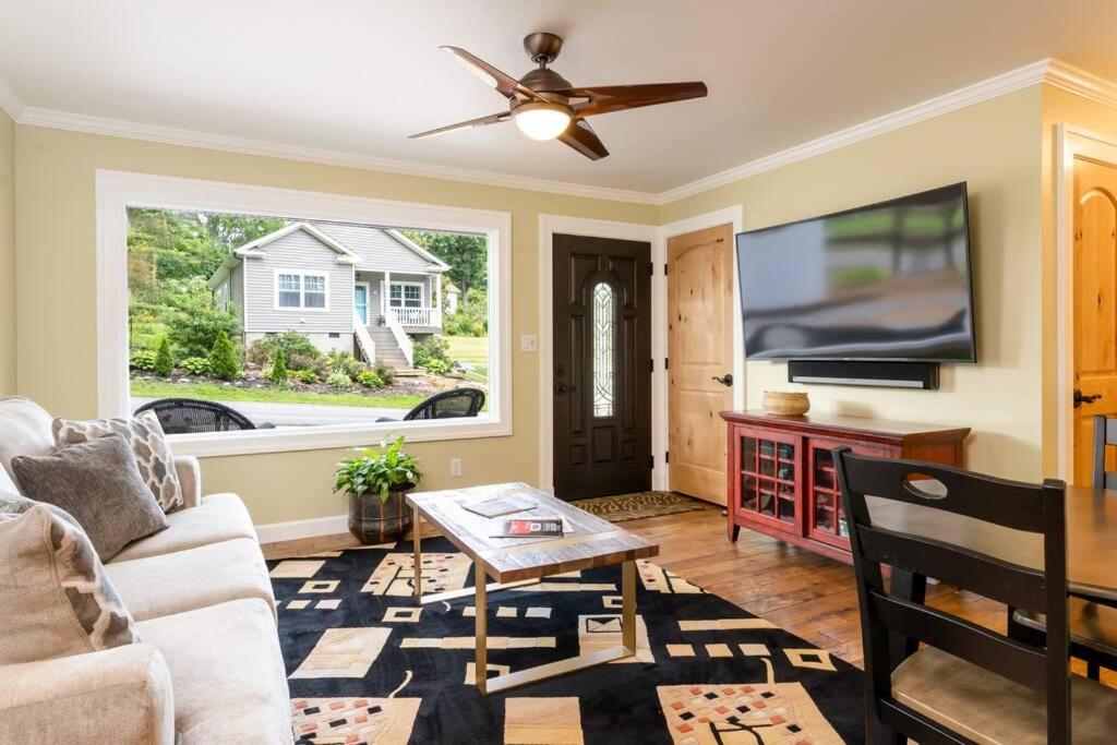 a living room with a couch and a tv at Luxury Cottage just 5 miles to downtown Asheville in Asheville