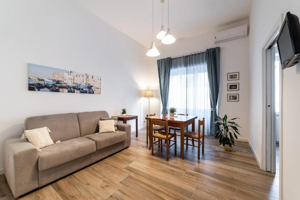 un soggiorno con un divano e un tavolo di Casa Donna Gina - Puglia Mia Apartments a Monopoli