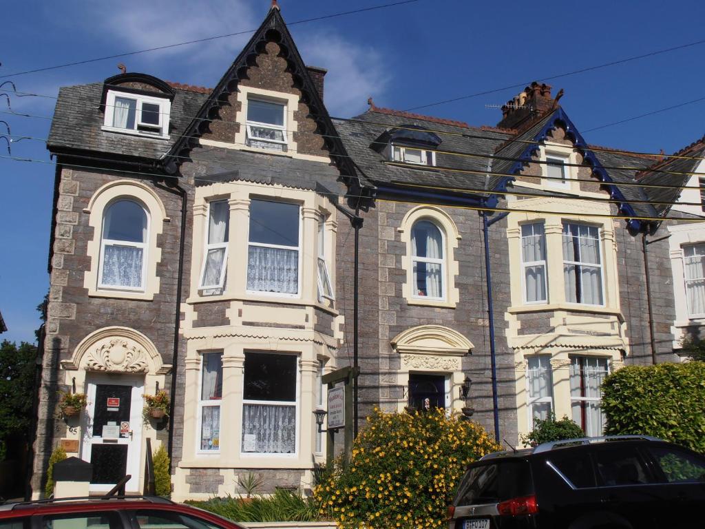 ein großes Backsteinhaus mit weißen Fenstern in der Unterkunft Meadowlea Guest House in Okehampton