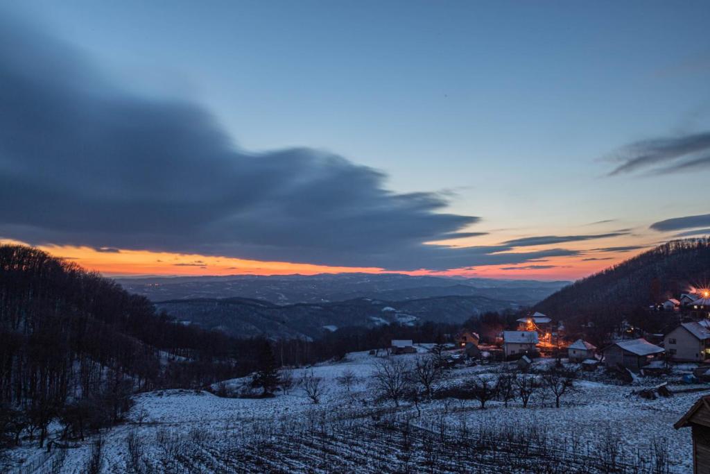 Blick auf ein Dorf im Schnee bei Sonnenuntergang in der Unterkunft Irinin Vidikovac in Rudnik